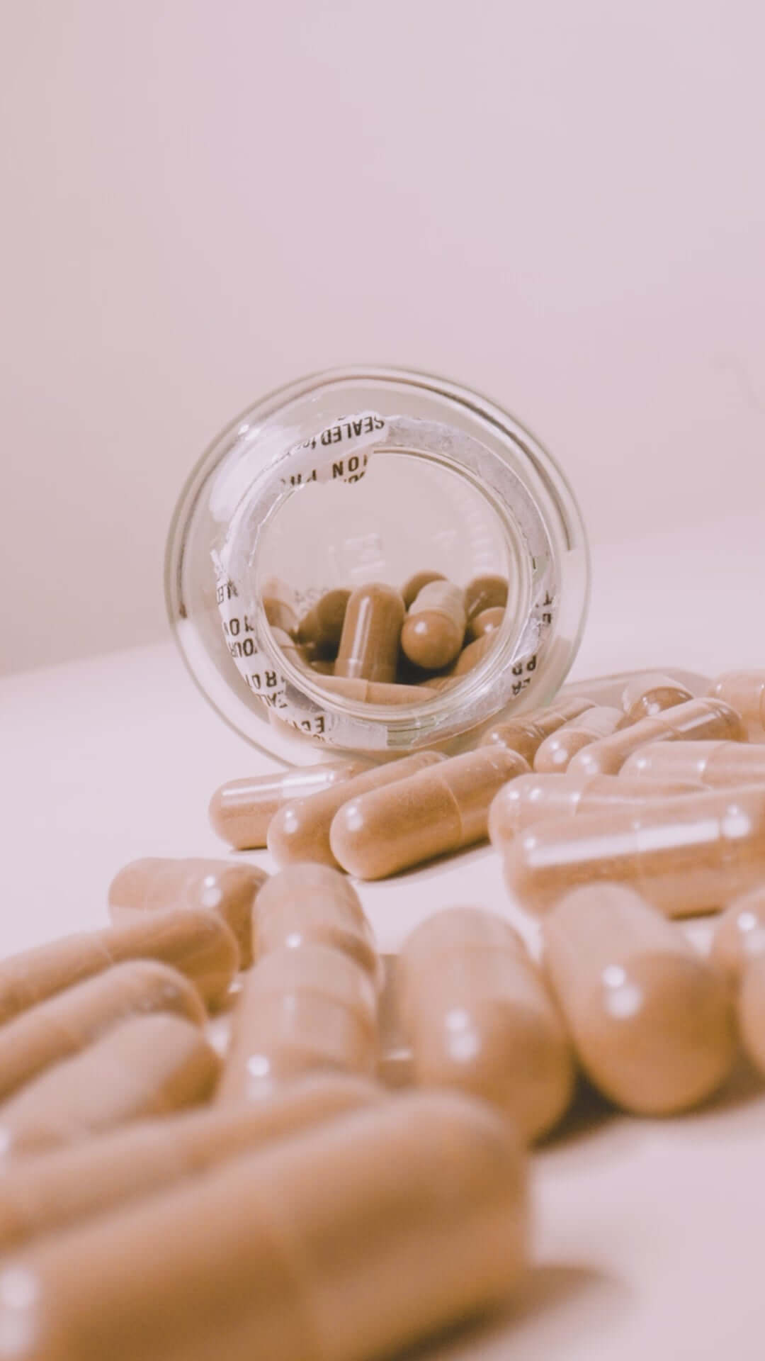 Close-up of Boombiotics Hair Growth Vitamin capsules in glass bottle. Nutrient-rich formula supports hair growth from within.